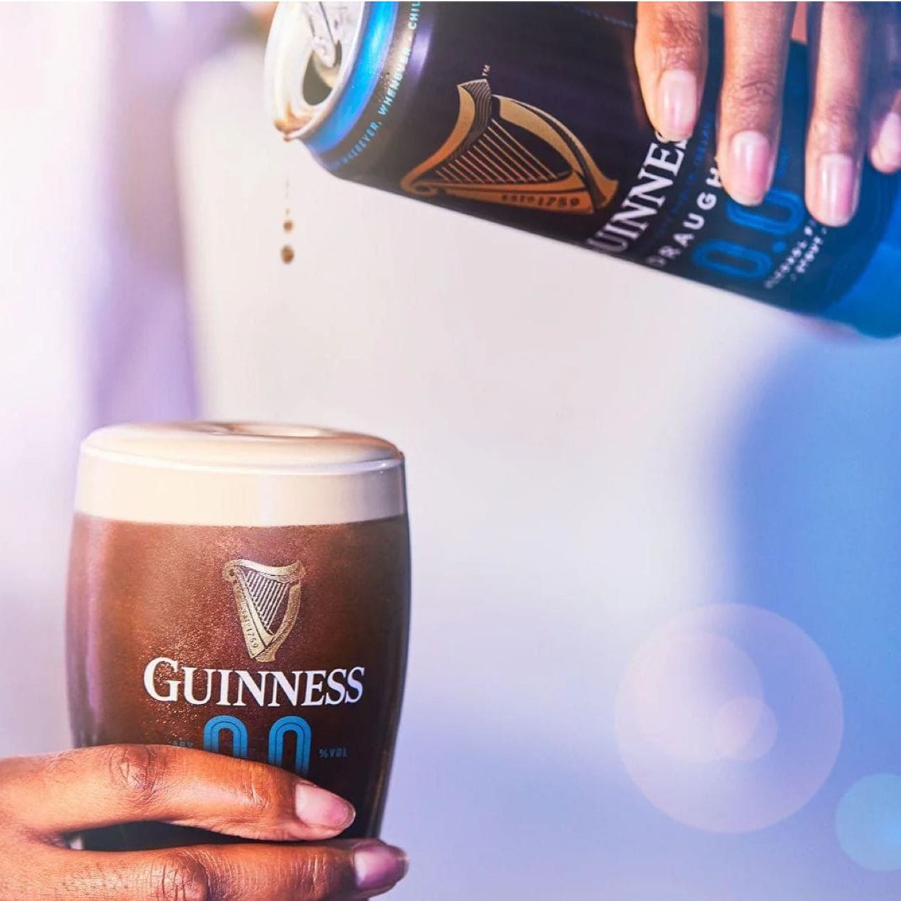 Flaske og dåse af Guinness 0.0 – alkoholfri stout med karakteristisk sort design og velkendt logo.